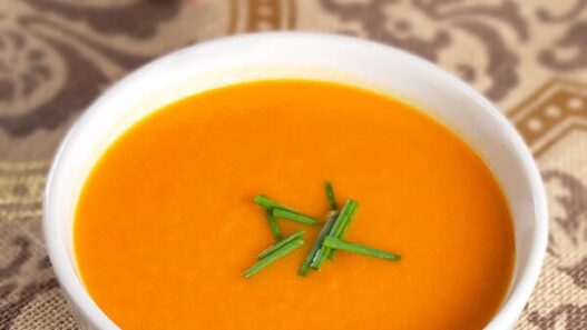 bowl of tomato and sweet potato soup with chives