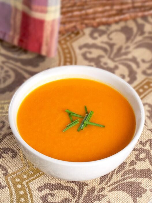 bowl of tomato and sweet potato soup with chives