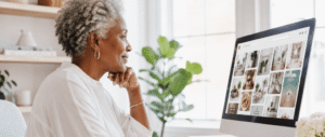Mature Black woman working on Pinterest at her computer in a light, modern home office, researching ideas and content strategy in a calm, minimalist workspace. She is searching for pinterest hacks